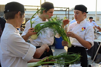 Three persons holding harvested onion leeks